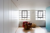 Modern bedroom with comfortable leather armchair below window