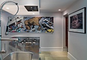 Stainless steel kitchen island and picture with comic motif on wall