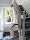 Staircase with turned balusters and patterned runner on stairs