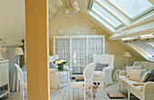 Attic living room with sloping ceilings, light-colored furniture and brick wall