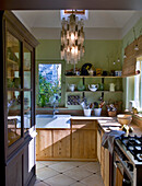 Country-style wooden kitchen with hanging lamp and green walls