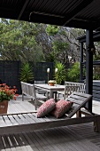 Cushions on modern wooden lounger and table set on Mediterranean terrace