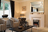 Striped armchairs and modern coffee table in front of fireplace