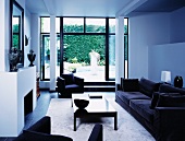 Schwarze Sofagarnitur in weißem modernen Wohnraum mit Blick auf Terrasse