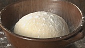 A ball of dough being dusted with flour