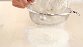 Sieving flour onto a worksurface