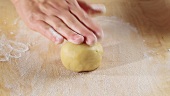 Dusting a worksurface with flour and rolling out shortbread dough