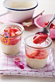 Spooning semolina and rhubarb and strawberry compote into individual pots