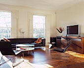 Black leather, retro armchairs and couch in living room with classic ambience