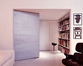 Wohnraum mit schräg gestelltem Raumteiler und Blick auf Bücherregal