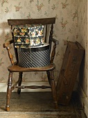 Old suitcase in corner & hatboxes on wooden chair