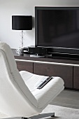 White, swivel chair in front of TV