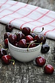 Cherries in bowl & on wooden table
