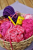 Wool basket with balls of wool, crocheting needle and knitting dolly
