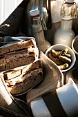 Picnic hamper with sandwiches, drinks and cookies