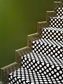 Stair treads with spotted carpet against green wall