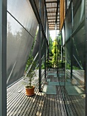 Sunshade panels offset from glass facade above wooden decking