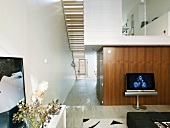 Zweigeschossiger Wohnraum im modernen, schmalen Grundriss mit Untersicht auf die Trepppe und die verglaste Galerie-Ebene