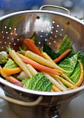Washed vegetables in colander (carrots, onions, Savoy cabbage)