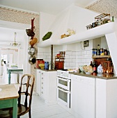 weiße Küchenzeile mit gemauertem Dunstabzug