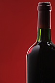 Bottle of red wine against a red background