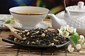 Dried green tea with jasmine blossom and a cup of jasmine tea