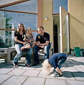 Young family on the terrace in front of a modern house