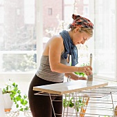 Lady painting a wooden shelf