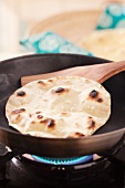 Cooking tortilla flatbread in a pan