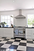 Vintage kitchen with stainless steel cooker and black and white chequered floor