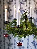 Hanging Advent wreath with burning candles and Christmas decorations