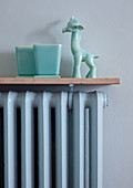 Pastel blue porcelain ornaments on cover of ribbed radiator