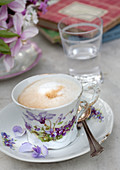 Cappuccino in einer Tasse mit Blumenmotiv