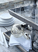 Christmas tree baubles and glasses on wooden étagère