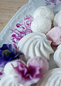 Meringues and coconut balls on a plate (close-up)