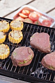 Fillet steaks stuffed with pesto on barbecue