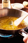 Ginger oil being heated in a pan