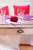 Festive table set with rose petals arranged in heart