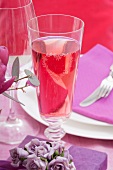 A glass of rosé sparkling wine on festive table