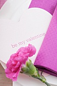 Place setting with carnation and heart-shaped Valentine's Day name card