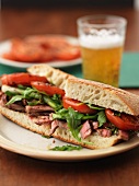 Sandwich with beef steak, tomatoes and rocket