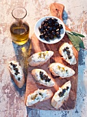 Baguettescheiben mit Brandade (Stockfischpüree, Provence), Oliven, Olivenöl