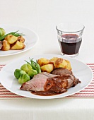 Roast beef with red wine sauce, potatoes and brussels sprouts