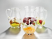 Three pitcher of ice water with fresh fruit