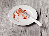 Left over strawberry compote on a plate with a knife