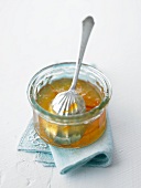 Orange marmalade in a glass dish with a spoon
