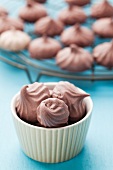 Brown meringues in a dish on a kitchen rack