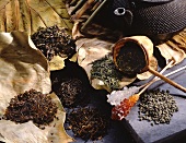 Assorted varieties of tea, rock candy sticks, tea strainer and tea pot