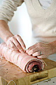 Making rolled pork roast with garlic, sage and quince relish