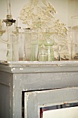 Collection of antique glass vases on shabby chic cupboard